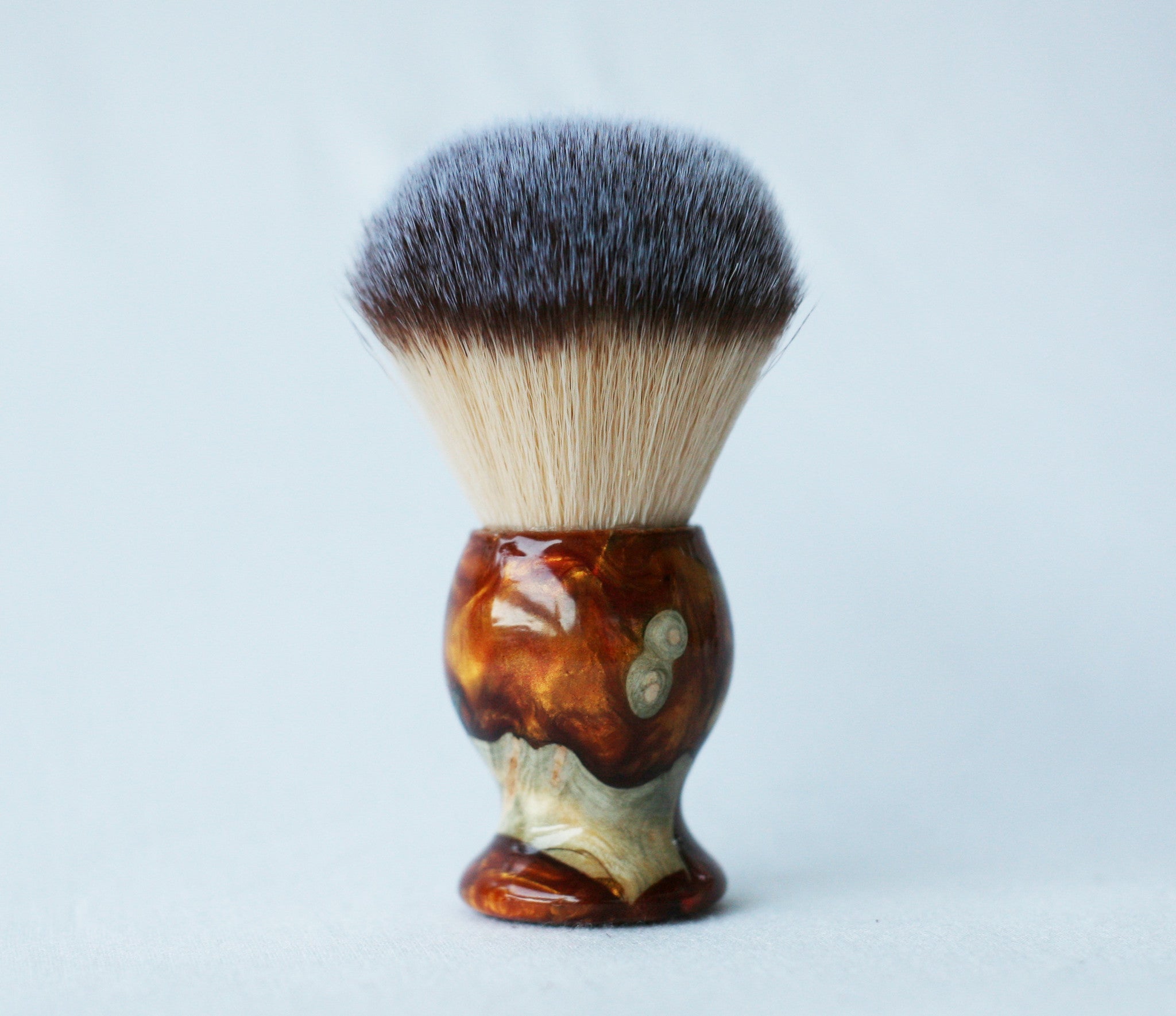 Rasierset aus Buckeye-Maserholz mit Sicherheitsrasierer aus Harz in Gold-Rot-Maserung, 26-mm-Rasierpinsel und passendem Rasierständer.